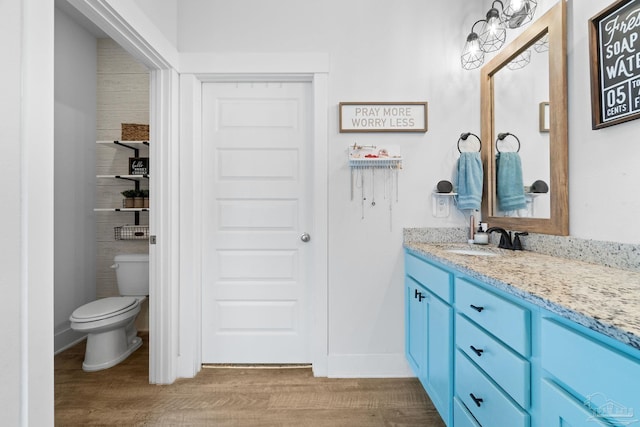 5722 Conley Ct, Pace, FL 32571 - bathroom featuring vanity, toilet, wood finished floors, and baseboards