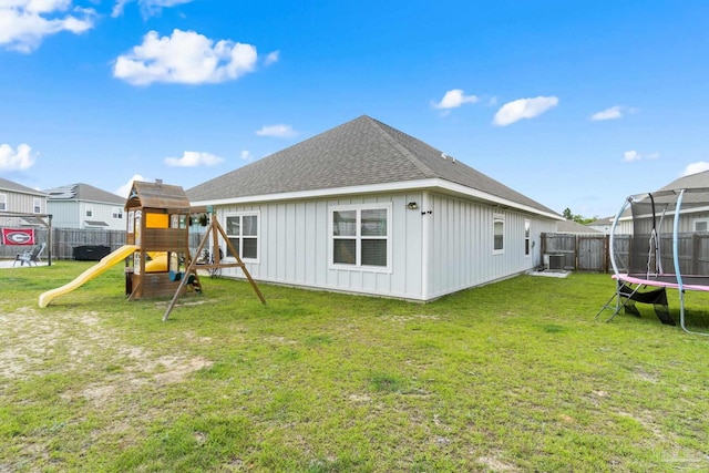 5722 Conley Ct, Pace, FL 32571 - back of property featuring a trampoline, board and batten siding, a playground, roof with shingles, and central air condition unit