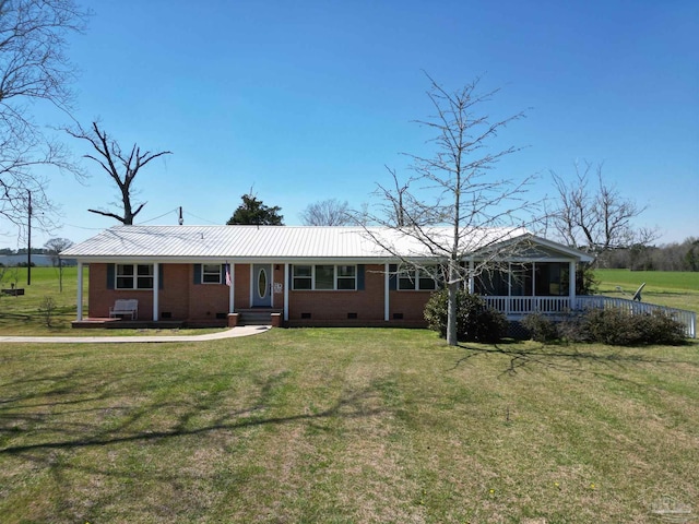 ranch-style house featuring brick siding, a front yard, metal roof, a sunroom, and crawl space