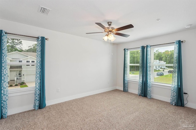 carpeted spare room featuring ceiling fan