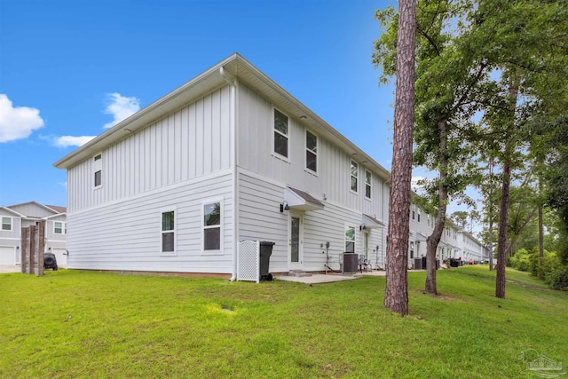 rear view of property with a patio, a lawn, and central air condition unit