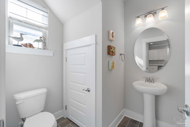 bathroom featuring toilet and lofted ceiling