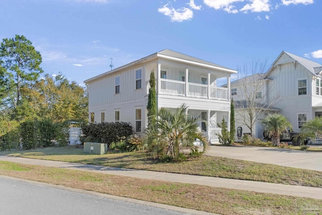 view of front facade with a balcony and a front lawn