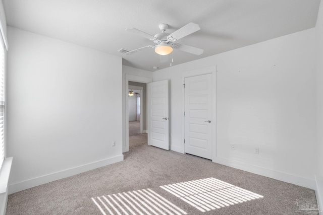 unfurnished bedroom with ceiling fan and light colored carpet