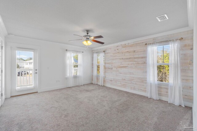 empty room with ceiling fan, light carpet, and a wealth of natural light