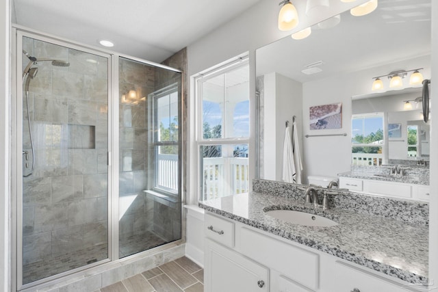 bathroom featuring vanity and a shower with door