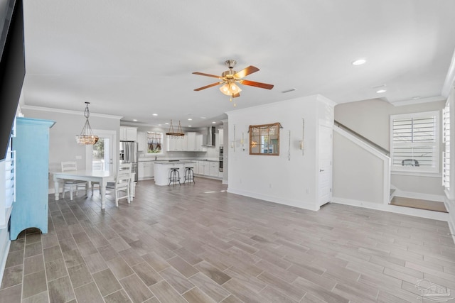 living room featuring light hardwood / wood-style floors, ceiling fan, and ornamental molding