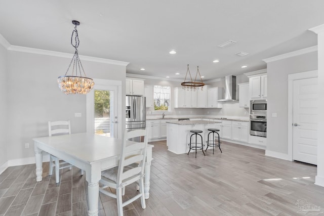 dining room with light wood-type flooring, ornamental molding, and sink