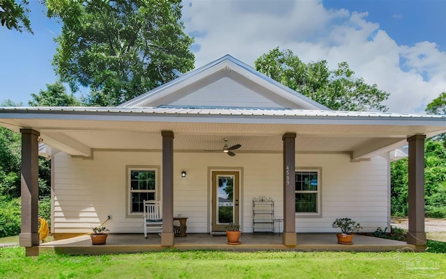 back of property featuring covered porch, a ceiling fan, and metal roof