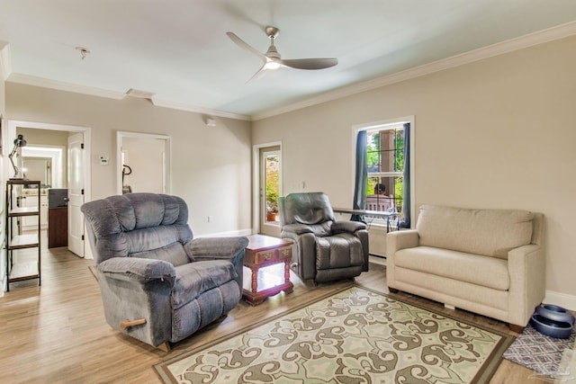 living room with light wood-type flooring, ornamental molding, baseboards, and ceiling fan
