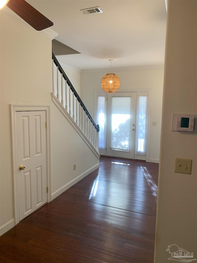 entrance foyer featuring dark hardwood / wood-style flooring and crown molding