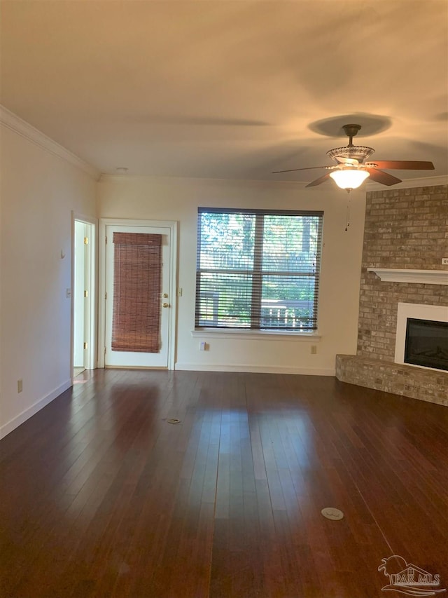 unfurnished living room featuring crown molding, a fireplace, dark hardwood / wood-style floors, and ceiling fan