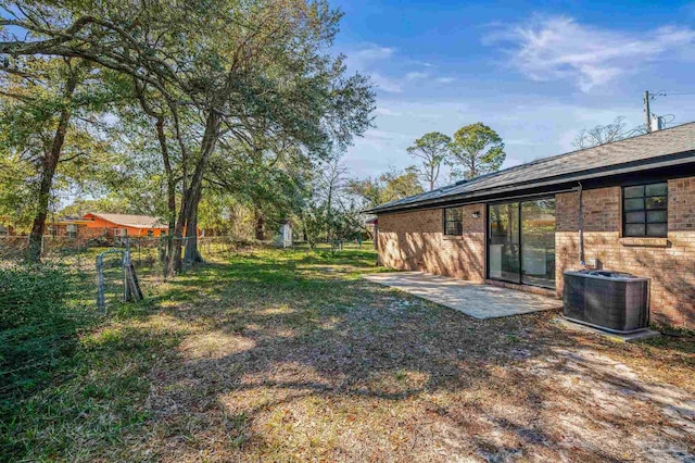 view of yard with a patio, central AC, and fence