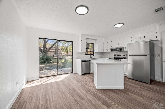 kitchen featuring a sink, visible vents, appliances with stainless steel finishes, and wood finished floors