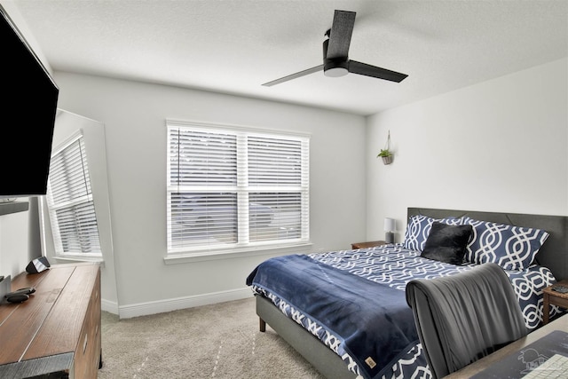 carpeted bedroom featuring multiple windows and ceiling fan