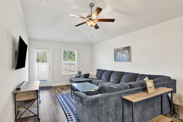 living room featuring vaulted ceiling, ceiling fan, and dark wood-type flooring