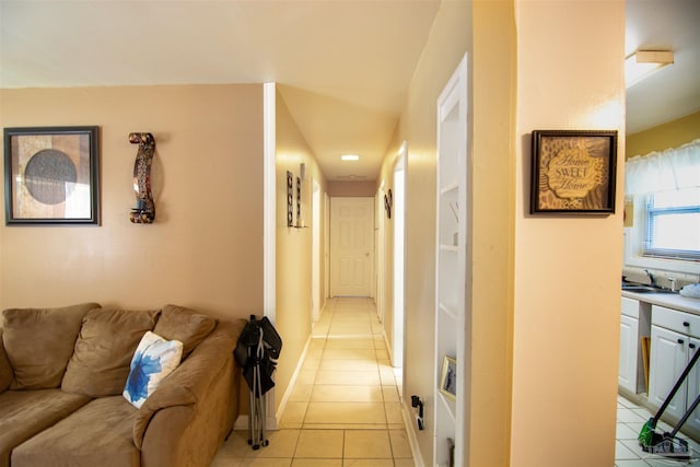 hall with sink and light tile patterned flooring