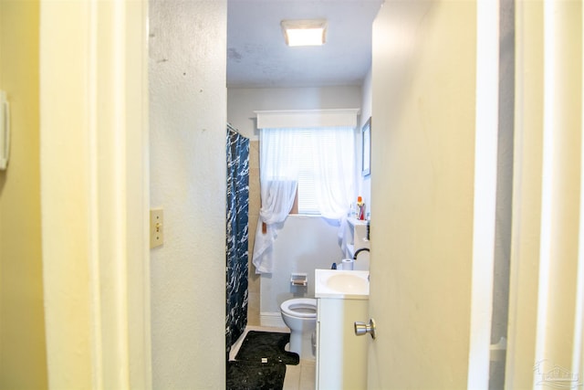 bathroom featuring tile patterned flooring, vanity, and toilet