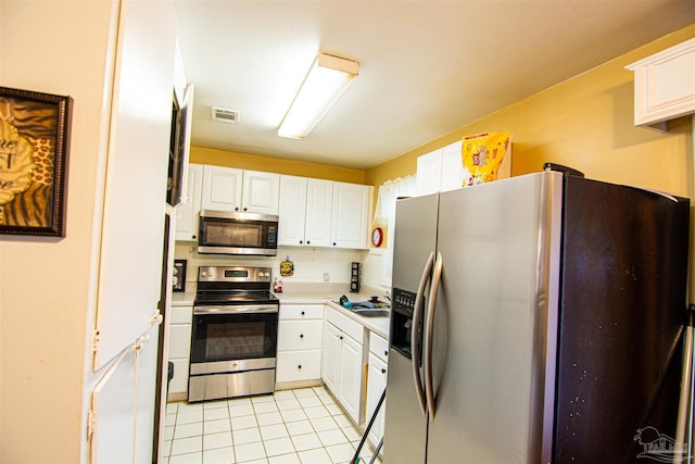 kitchen featuring white cabinets, light tile patterned flooring, sink, and appliances with stainless steel finishes