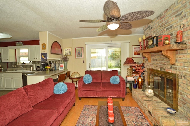 5845 Keystone Rd, Pensacola, FL 32504 - living area featuring ceiling fan, light wood finished floors, a textured ceiling, and a brick fireplace