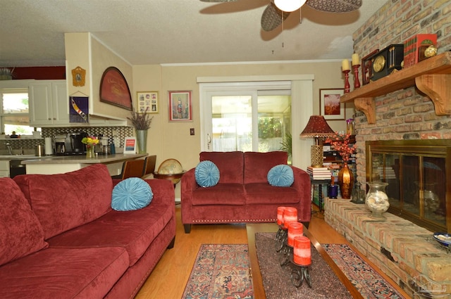 5845 Keystone Rd, Pensacola, FL 32504 - living room with light wood-style flooring, healthy amount of natural light, a ceiling fan, and a brick fireplace