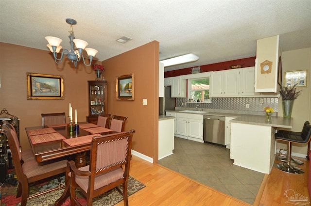 5845 Keystone Rd, Pensacola, FL 32504 - dining space with a chandelier, light wood-style floors, and a textured ceiling
