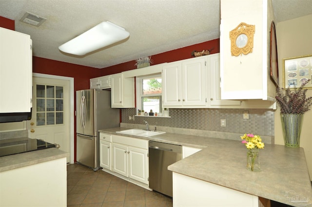 5845 Keystone Rd, Pensacola, FL 32504 - kitchen featuring appliances with stainless steel finishes, a sink, backsplash, white cabinets, and a textured ceiling