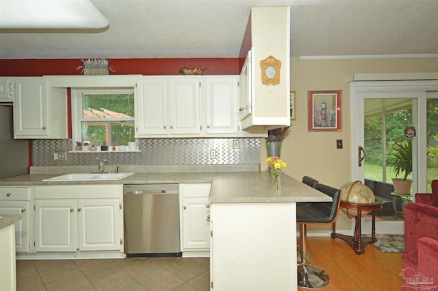 5845 Keystone Rd, Pensacola, FL 32504 - kitchen with stainless steel dishwasher, a breakfast bar, a sink, light countertops, and a textured ceiling