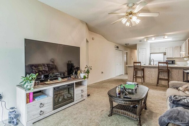 living room with light colored carpet, ceiling fan, and sink