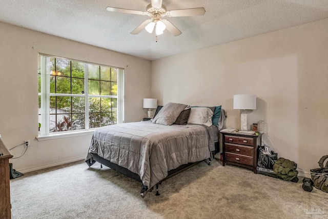 carpeted bedroom with ceiling fan and a textured ceiling