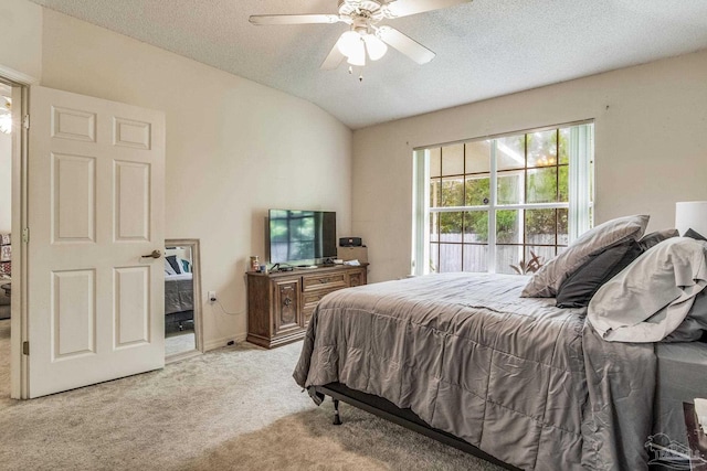 carpeted bedroom with lofted ceiling, ceiling fan, and a textured ceiling