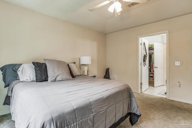 carpeted bedroom featuring ceiling fan, a closet, and a spacious closet