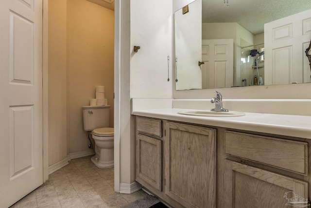 bathroom with vanity, a shower, a textured ceiling, and toilet