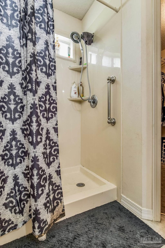 bathroom featuring a textured ceiling and walk in shower