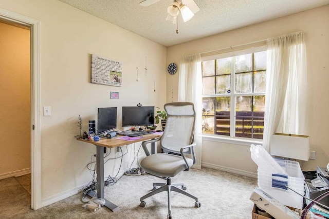 carpeted office space with a textured ceiling and ceiling fan