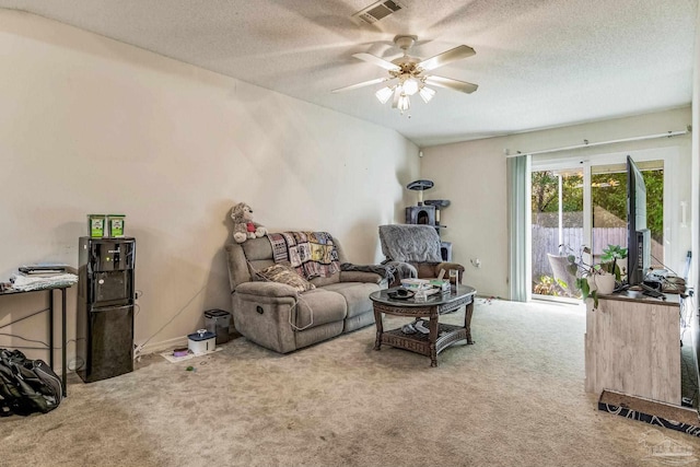 carpeted living room featuring ceiling fan and a textured ceiling