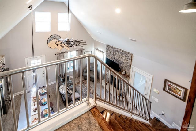 staircase with plenty of natural light and lofted ceiling