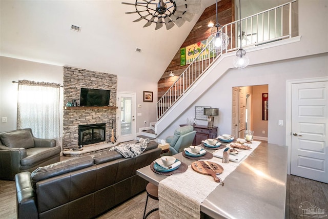 living room with wood-type flooring, a fireplace, and high vaulted ceiling