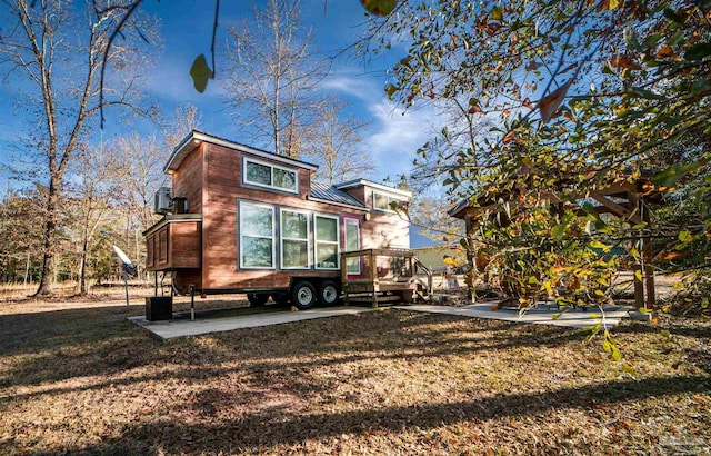 rear view of house with a deck, a yard, and a patio