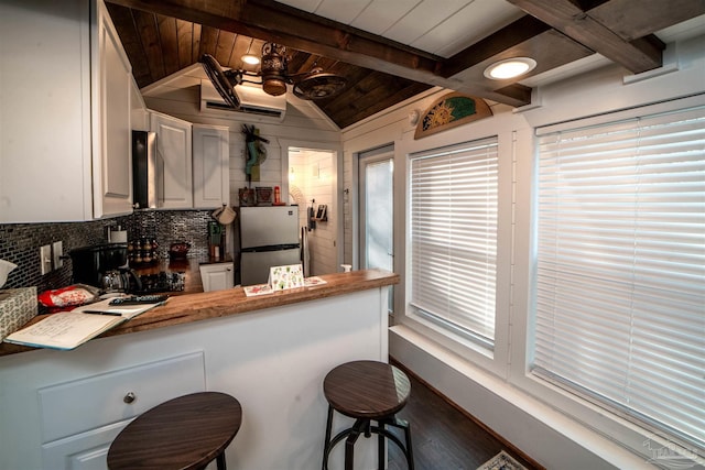 kitchen featuring wooden ceiling, white cabinets, decorative backsplash, stainless steel fridge, and ceiling fan