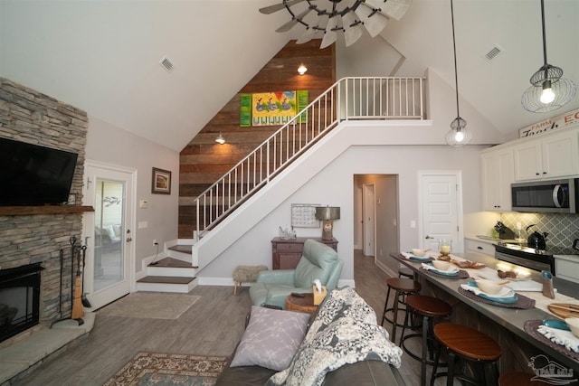 living room with a fireplace, dark hardwood / wood-style floors, and high vaulted ceiling