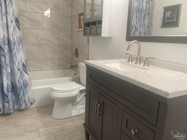 full bathroom featuring toilet, hardwood / wood-style floors, vanity, and shower / bath combo