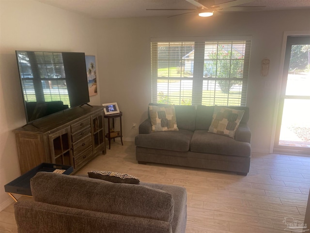 living room with light hardwood / wood-style floors, a wealth of natural light, and ceiling fan