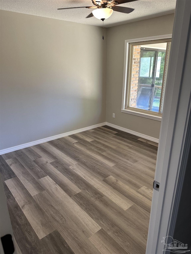 5303 Mikes Pl, Milton, FL 32570 - unfurnished room featuring dark wood finished floors, a textured ceiling, baseboards, and ceiling fan