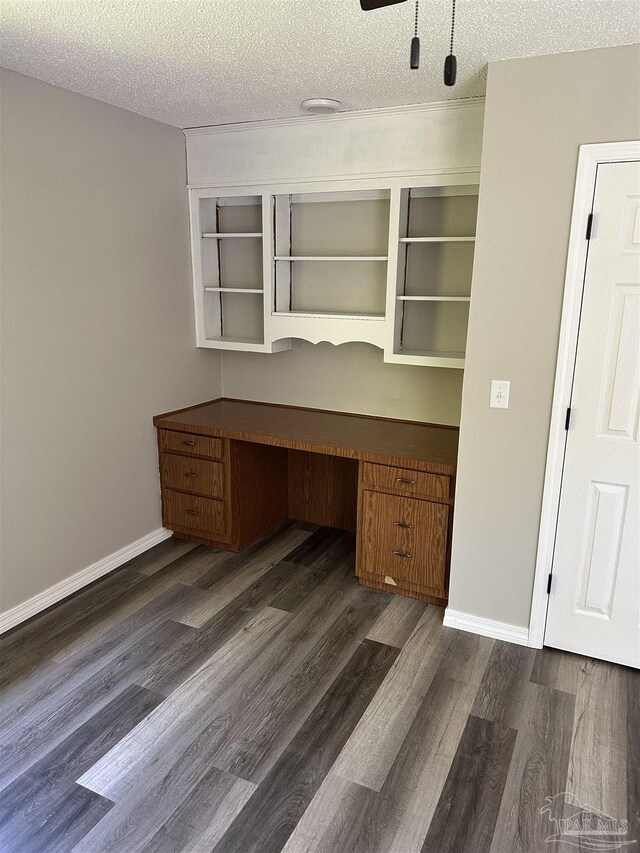 5303 Mikes Pl, Milton, FL 32570 - unfurnished office with built in desk, baseboards, dark wood finished floors, and a textured ceiling