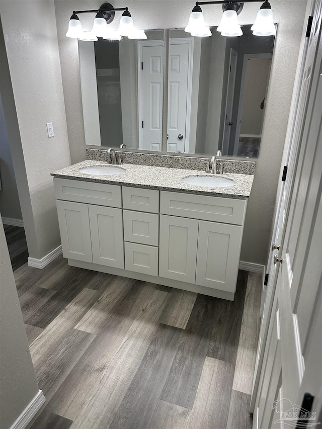 5303 Mikes Pl, Milton, FL 32570 - bathroom with wood finished floors, double vanity, a sink, and baseboards