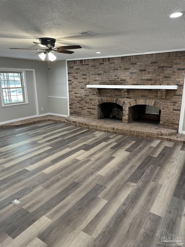 5303 Mikes Pl, Milton, FL 32570 - unfurnished living room featuring baseboards, a fireplace, a textured ceiling, a ceiling fan, and wood finished floors
