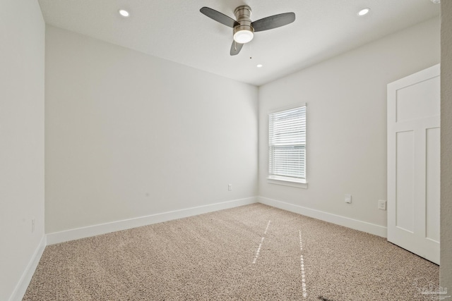 carpeted spare room featuring ceiling fan