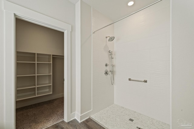 bathroom featuring hardwood / wood-style floors and a tile shower