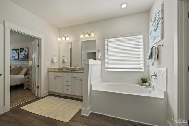 bathroom featuring hardwood / wood-style floors, vanity, and a bathing tub